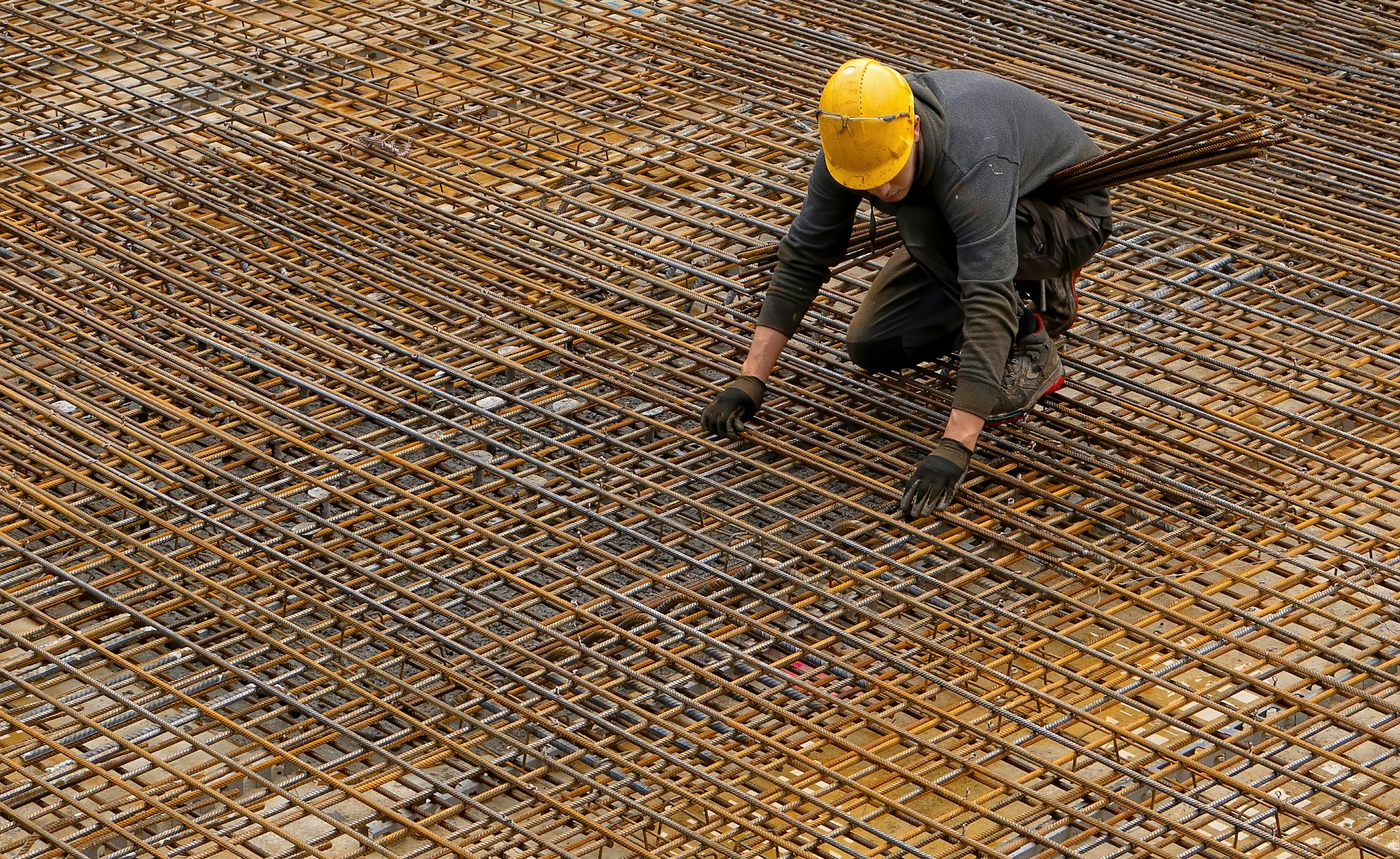 Worker installing reinforcement steel for structural concrete